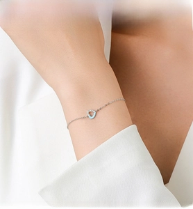 Close-up of S925 silver bracelet featuring a blue heart charm with micro-pave zircons