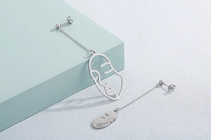 Boucles d'oreilles minimalistes en argent avec pendentifs visage abstrait sur fond bleu