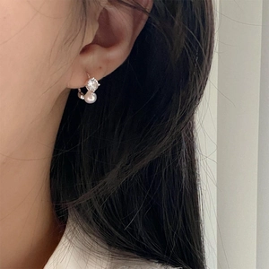 Close-up of 925 sterling silver earring with zircon and pearl on model's ear