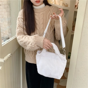 Détail d'un sac cabas en velours côtelé blanc avec bord froissé et bandoulière amovible