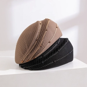 Detail of wool felt beret with mesh veil and wavy beaded accents on a pedestal