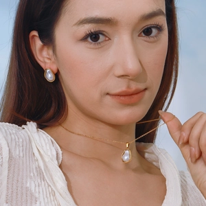 Elegant gold titanium steel jewelry set featuring irregular white pearls on a model