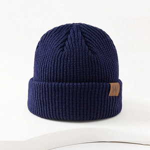 Winter navy blue ribbed knit beanie hat with square brown leather patch and letter W
