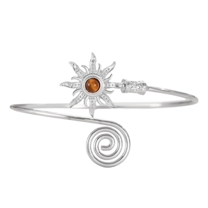 Detailed macro view of bohemian silver sun arm cuff featuring a brown stone center
