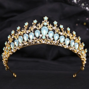 Detail of vintage gold crown with light blue teardrop stones on black satin