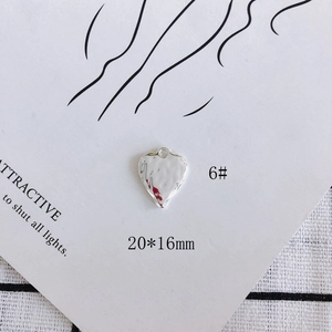 Detailed view of silver heart-shaped hammered metal pendant with 20x16mm size label