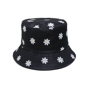 Close-up detail of small daisy print patterns on a black canvas fisherman sun hat