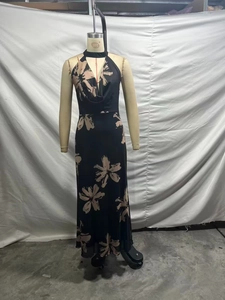 Detail of floral print halter neck dress featuring deep V-neck and cinched waistline