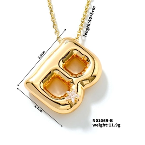 Macro detail of golden letter B bubble pendant with rhinestones and size dimensions