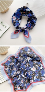 Detail of floral linen square scarf featuring navy blue prints and red striped edges