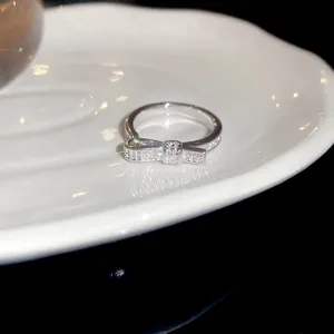 Polished silver 18k gold plated bow ring with sparkling zircons on a white tray