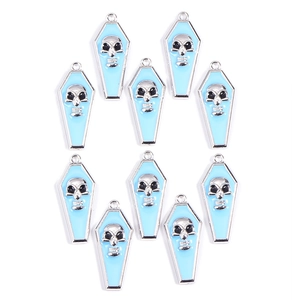 Macro view of light blue enamel vampire coffin and skull pendants for DIY jewelry