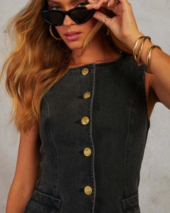 Détail du gilet en denim noir avec boutons dorés gaufrés et coupe cintrée moderne