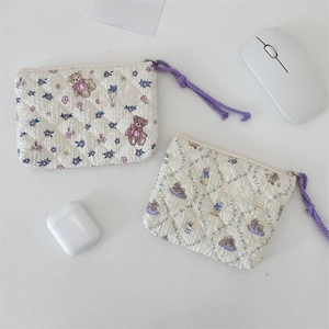 Close-up of quilted floral cosmetic bags with cute bear patterns and zip details