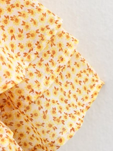 Dettaglio del tessuto a fiori gialli con cuciture ad alta densità e trama leggera