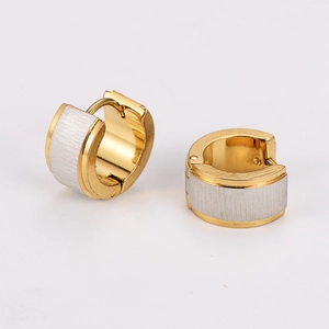 Macro detail of brushed silver inlay and polished gold finish on stainless steel earrings