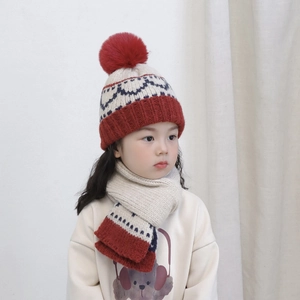 Detail of kids knit hat and scarf set with red pom-pom and wavy pattern in beige and red