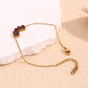 18K gold plated stainless steel bracelet with red garnet teardrop stones on stone base