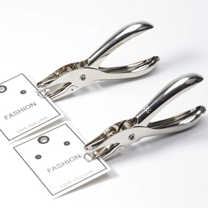 Detailed close-up shot of two shiny metal hole puncher tools working on paper tags.