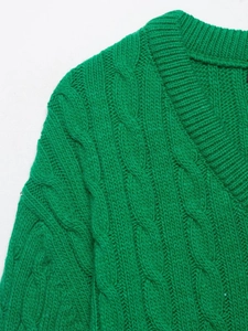 Close-up of bright green V-neck cable knit sweater with chunky ribbed neckline detail
