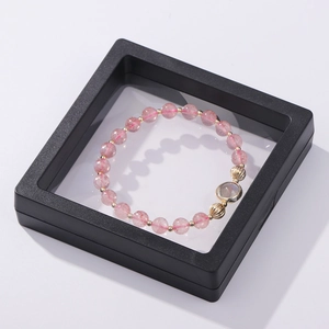 Pink beaded bracelet with gold accents displayed in a black PE film floating frame