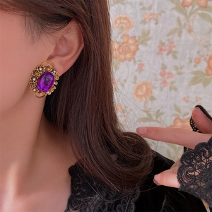 Detail of vintage oval purple gemstone ear clip with pearls on model's ear