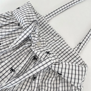 Detail of checkered tote bag with bow embroidery and secure magnetic buckle closure