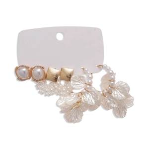 Elegant gold earrings set with pearls and petal tassels shown on a white card display