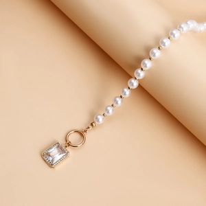 Close-up of pearl necklace with gold OT buckle and rectangular crystal pendant
