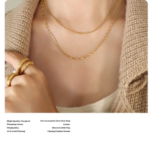 Detail of 18k gold plated double layer titanium steel snake chain necklace and gold ring