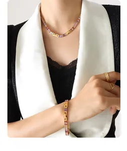 Detail of gold necklace and bracelet set with colorful baguette-cut stones on a model