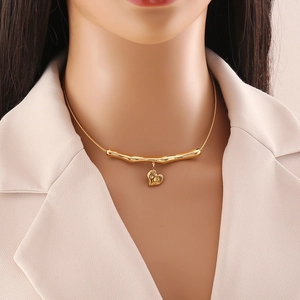 Irregular gold metal necklace with heart pendant and snake chain on model