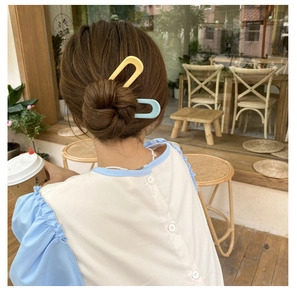 U-shaped hair pins in light yellow and blue styled in a bun for a sweet look
