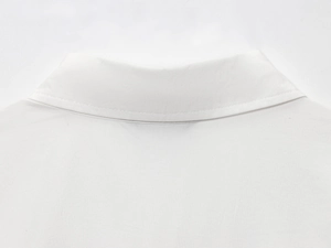 Dettaglio del colletto della camicia bianca in popeline con bottone gioiello e cucitura