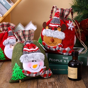 Detail view of plaid Christmas gift bags with snowman and elk patterns on a wooden desk