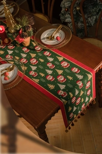 Close-up of green Christmas table runner with festive embroidery and red tassels