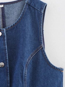 Détail du gilet en jean bleu montrant coutures contrastées, bouton métal et taille S