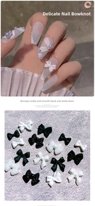 Close-up of 3D resin bow nail charms in black and white with matte and smooth finishes