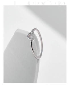 Detail of S925 sterling silver ring with heart-shaped moissanite on white geometry