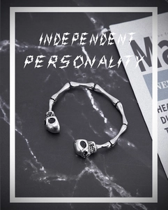 Macro shot of silver stainless steel skull bone bracelet on a dark marble surface