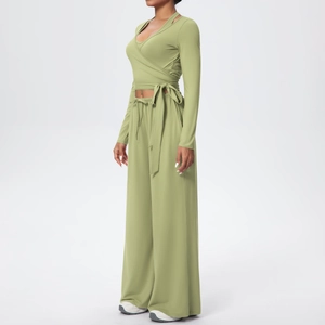 Détail de la taille croisée à nouer et du pantalon de yoga taille haute évasé vert olive