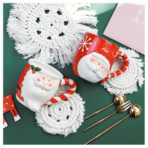 Close-up of a 3D Santa Claus ceramic mug with a candy cane handle on a green background