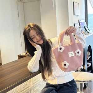Close-up of pink plush handbag featuring 3D floral embroidery and sozakka label