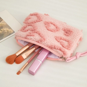 Detail of pink plush teddy fleece makeup bag showing texture, lining and zipper puller