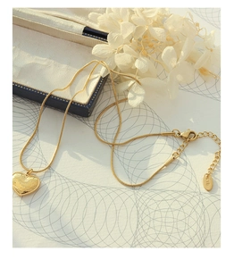 Close-up of heart pendant with I Love You engraving on a sleek gold snake chain