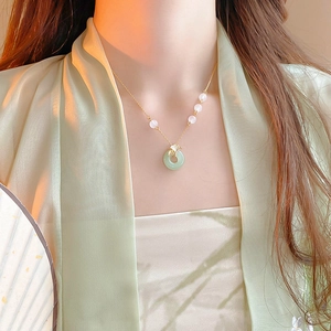 Détail du collier feuille de ginkgo plaqué or avec pendentif en jade vert et perles