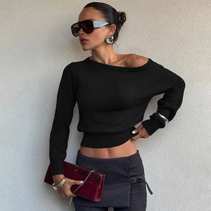 Gros plan sur le haut court en maille noire avec une encolure asymétrique chic