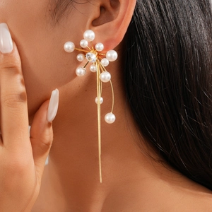 Close-up of elegant long tassel pearl earrings with zircon floral accents on a model