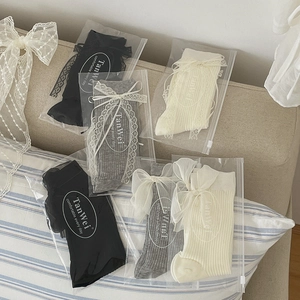 Sweet Lolita mid-calf socks with lace trim and bows in black, grey, and white colors