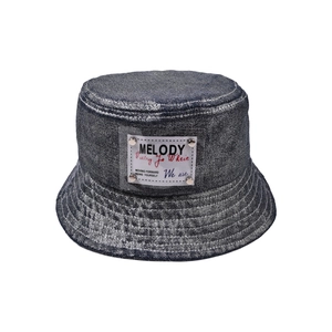Detalle de gorro de pescador en mezclilla oscura con parche de PVC y remaches metálicos
